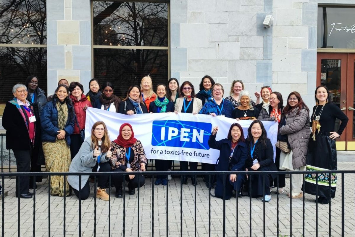 Group of women standing behind a white banner